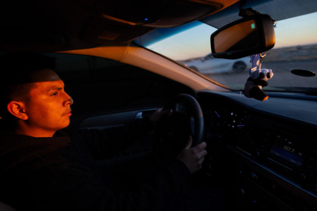 The sun rises as Marco Gutierrez, 20, drives to his home in Schuyler, Neb., following an overnight shift at Camaco Columbus Manufacturing on Thursday, Nov. 14, 2024. (By Rebecca S. Gratz)
